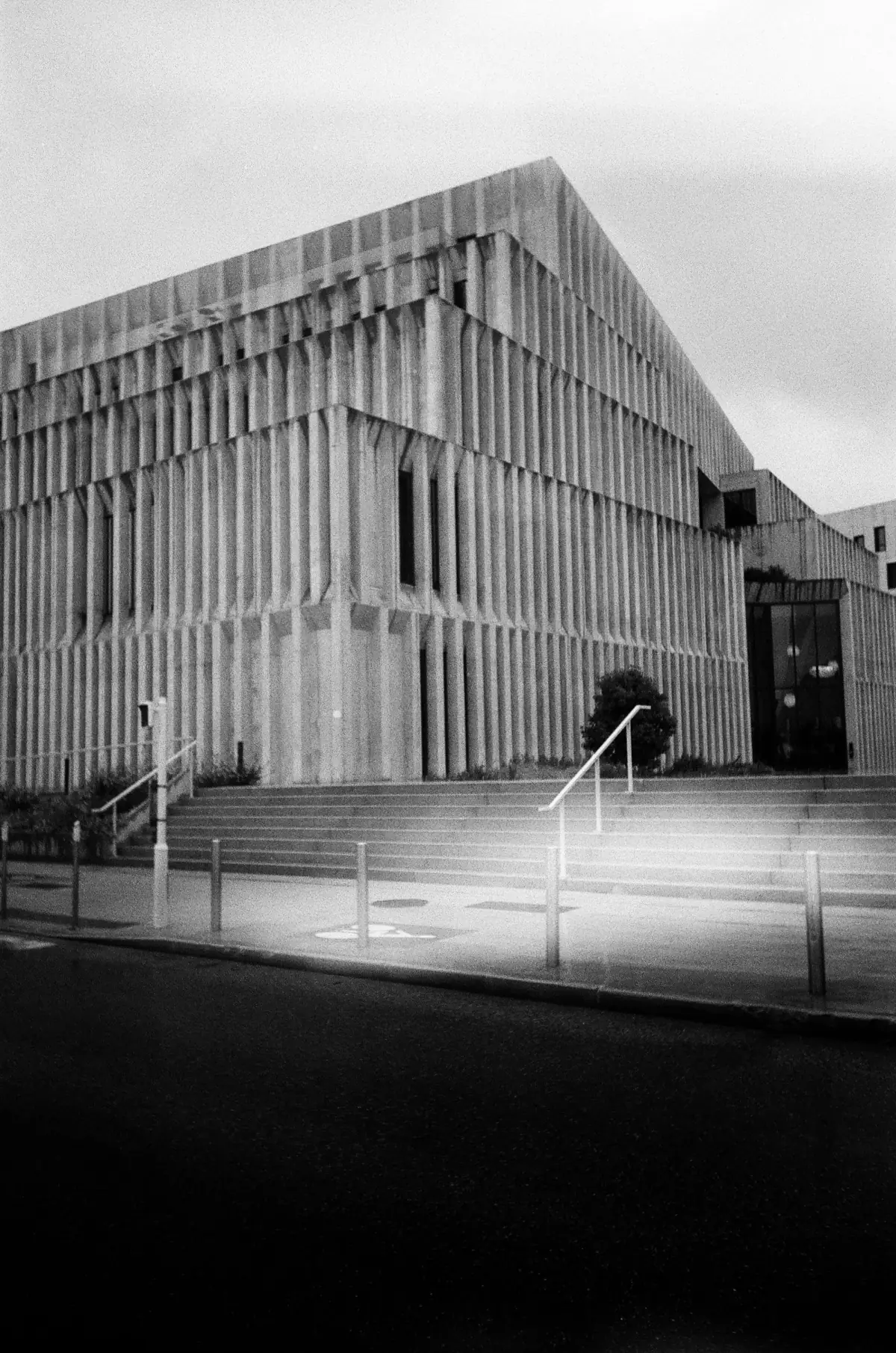 Black and white photograph of a brutalist concrete building with geometric stairs